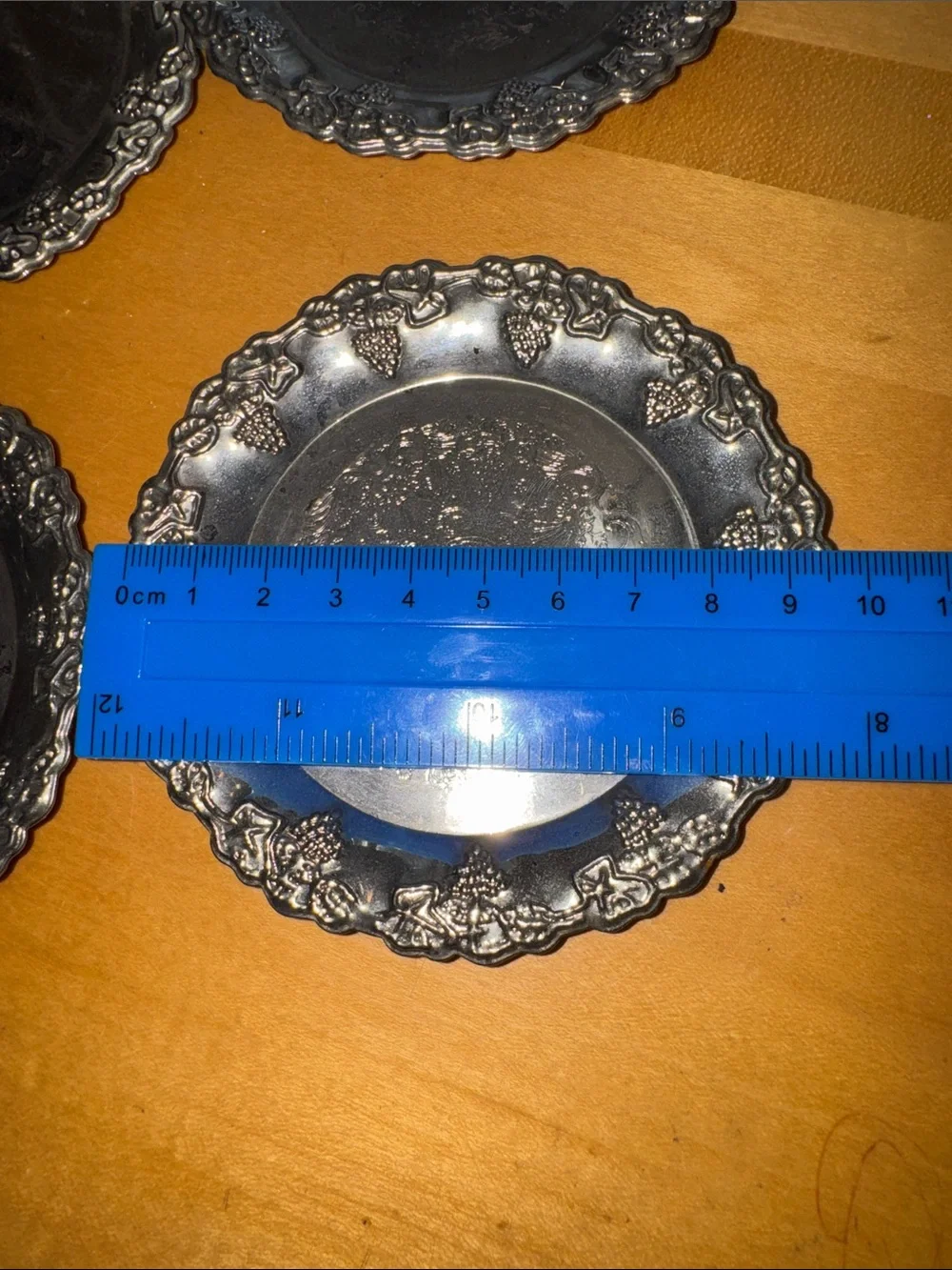 six vintage silver-plated drink coasters with ornate, embossed floral
